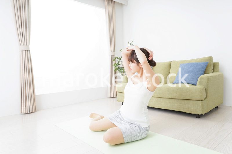 部屋でストレッチをする女性
