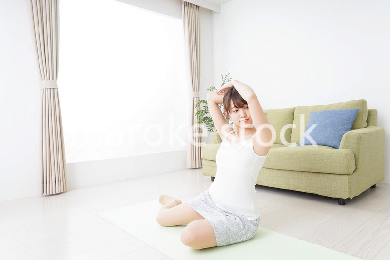 部屋でストレッチをする女性