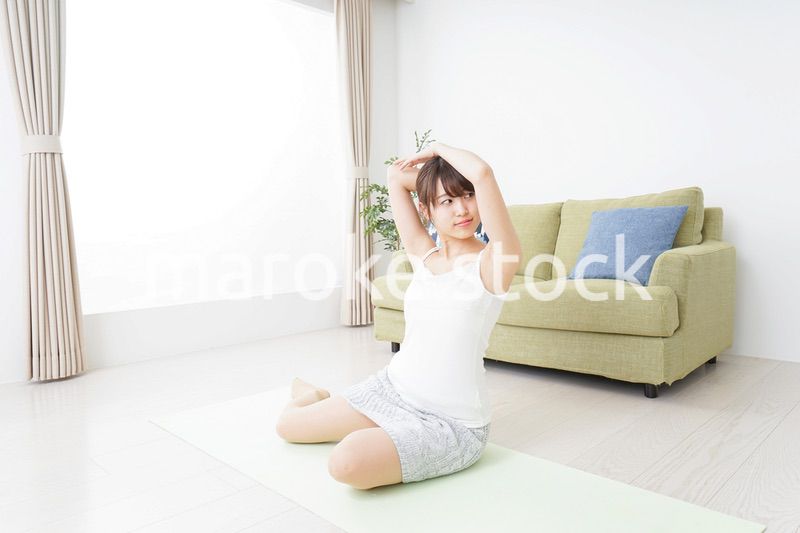 部屋でストレッチをする女性
