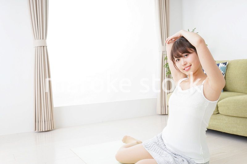 部屋でストレッチをする女性