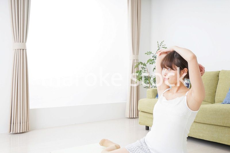 部屋でストレッチをする女性