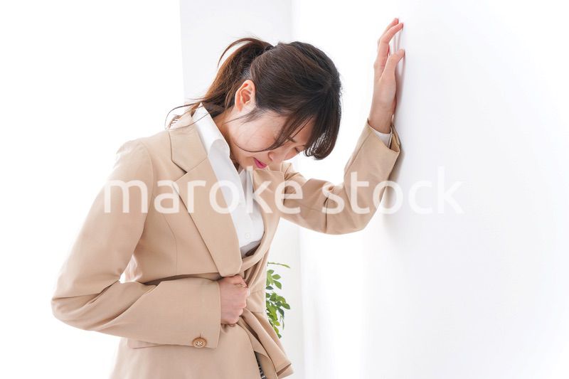 腹痛で苦しむビジネスウーマン