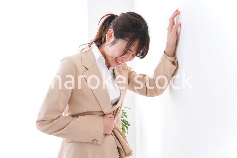 腹痛で苦しむビジネスウーマン