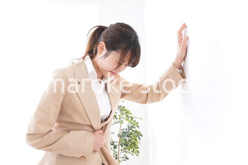 腹痛で苦しむビジネスウーマン