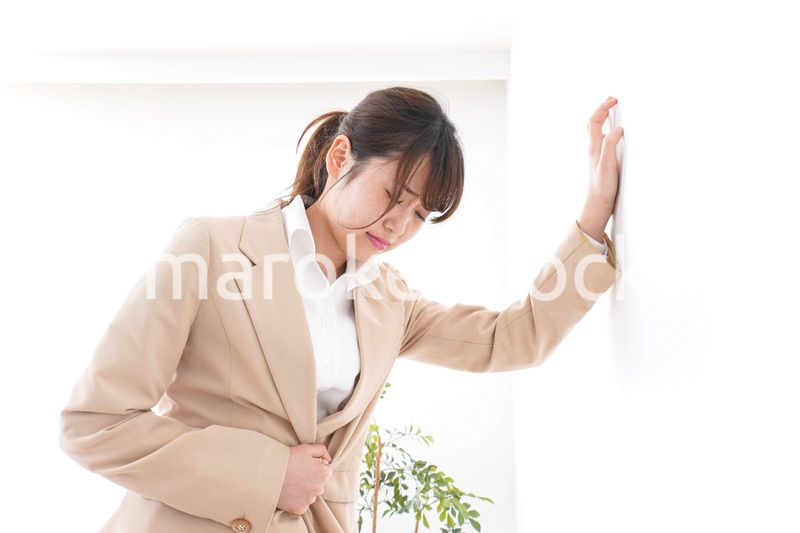 腹痛で苦しむビジネスウーマン