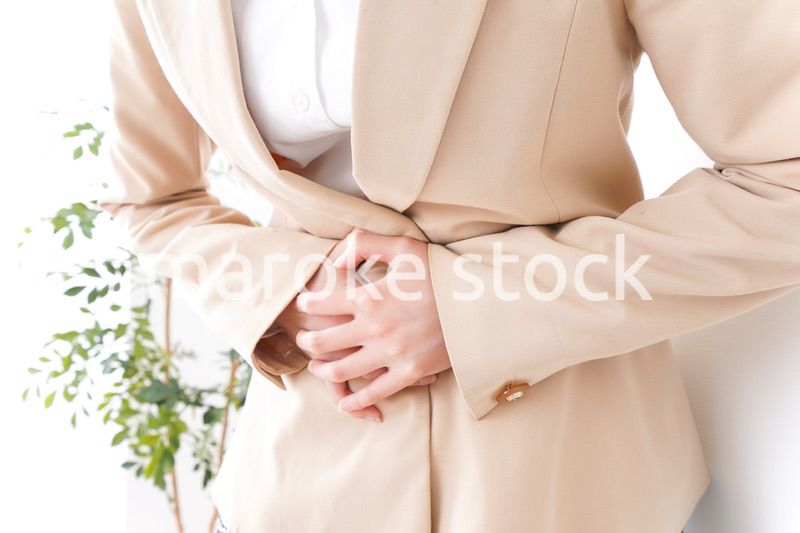 腹痛で苦しむビジネスウーマン