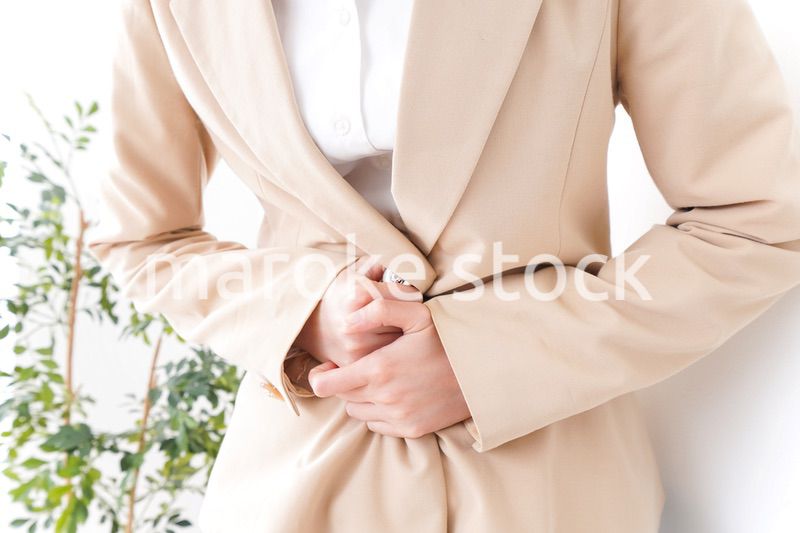 腹痛で苦しむビジネスウーマン