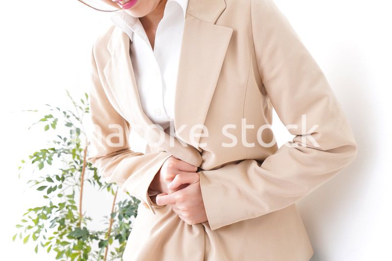 腹痛で苦しむビジネスウーマン