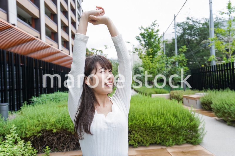伸びをする若い女性