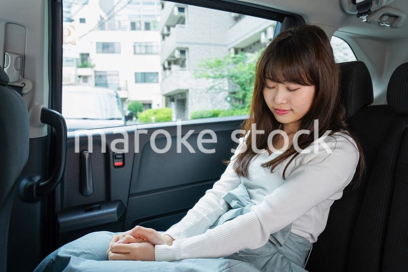 後部座席で寝る女性