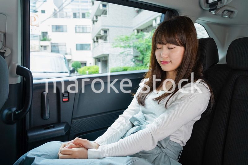 後部座席で寝る女性