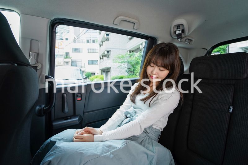 後部座席で寝る女性