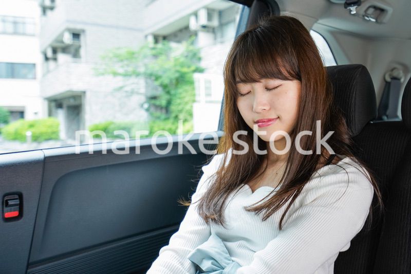 後部座席で寝る女性