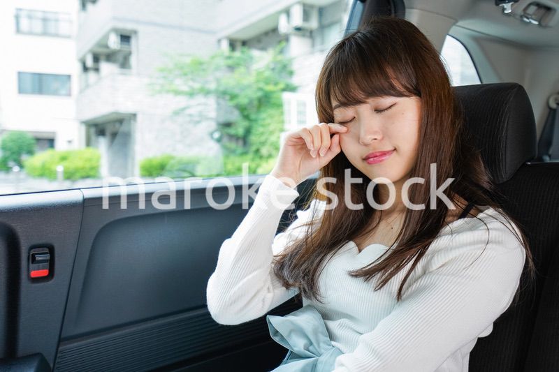 後部座席で寝る女性