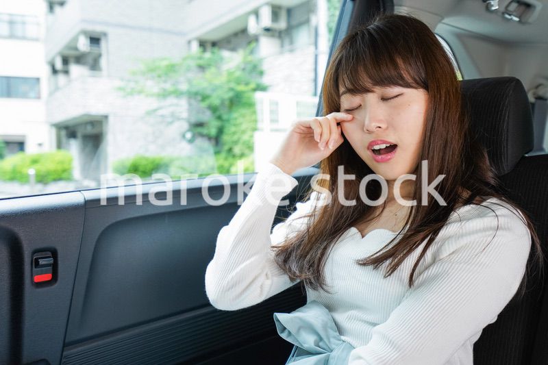 後部座席で寝る女性