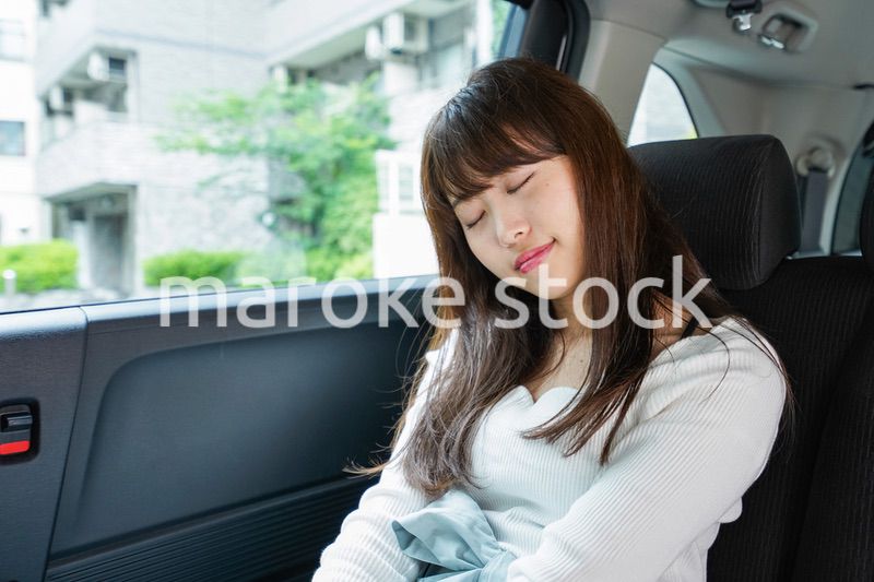 後部座席で寝る女性