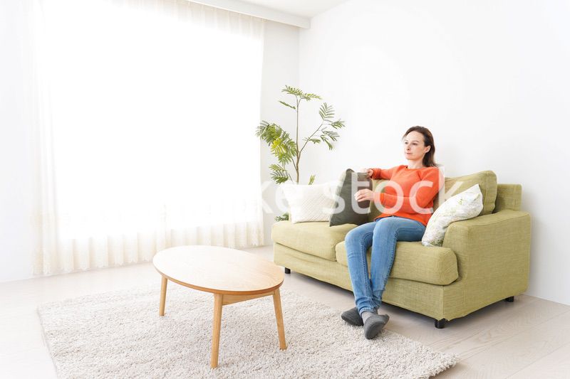 家でテレビを見る女性
