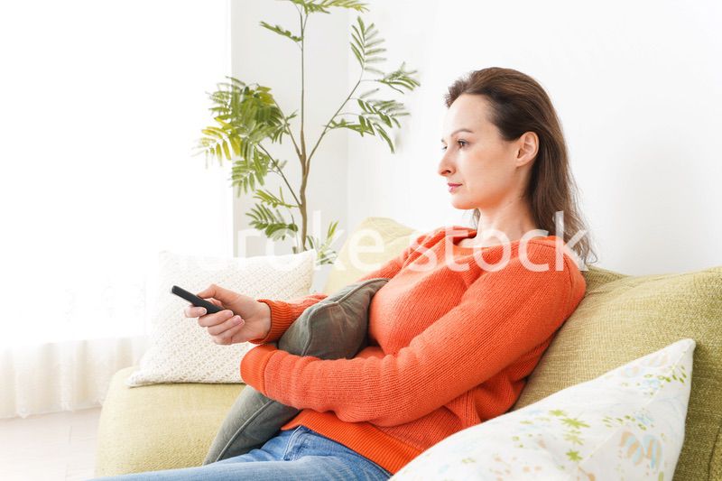 家でテレビを見る女性