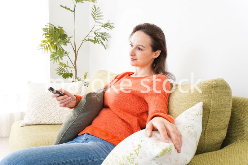 家でテレビを見る女性