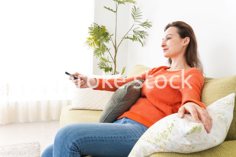 家でテレビを見る女性