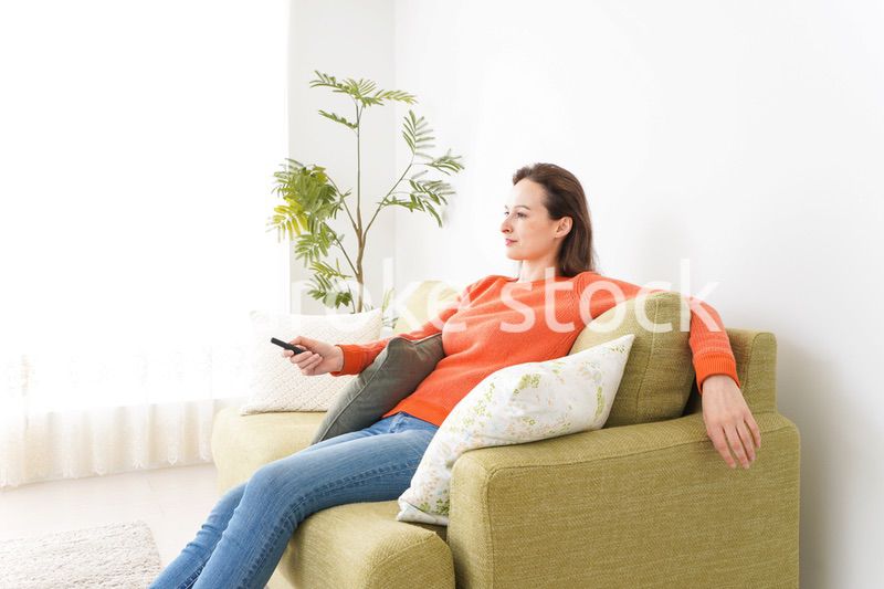 家でテレビを見る女性