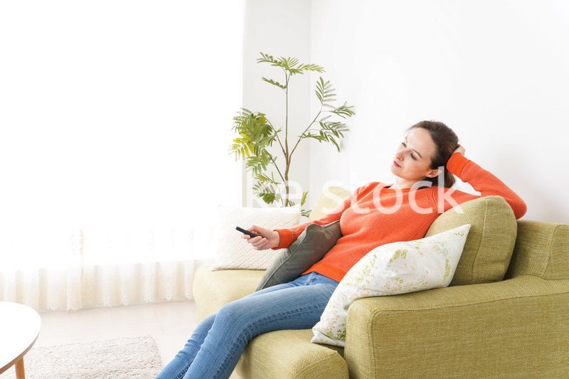 家でテレビを見る女性