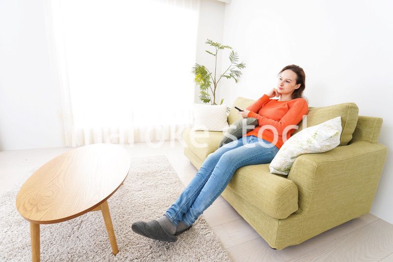 家でテレビを見る女性