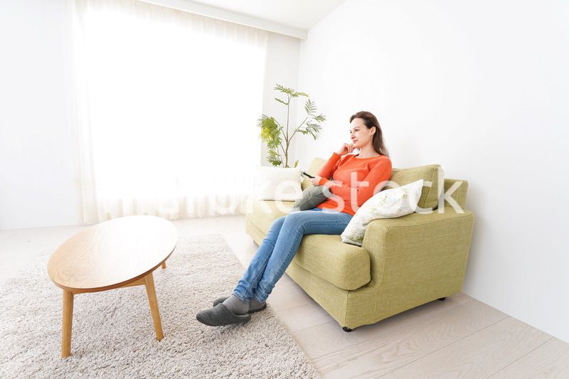 家でテレビを見る女性