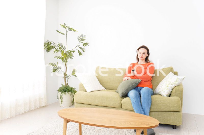 家でテレビを見る女性