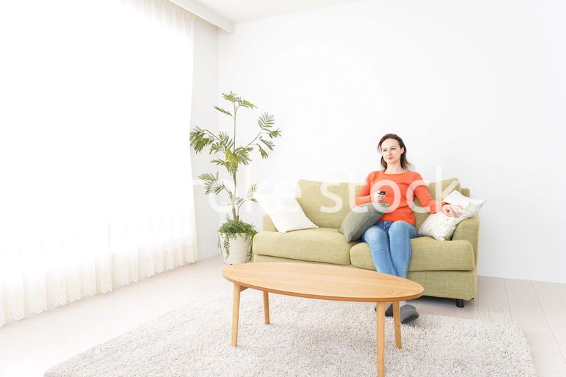 家でテレビを見る女性