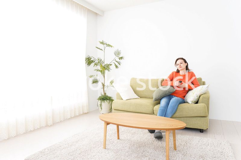 家でテレビを見る女性
