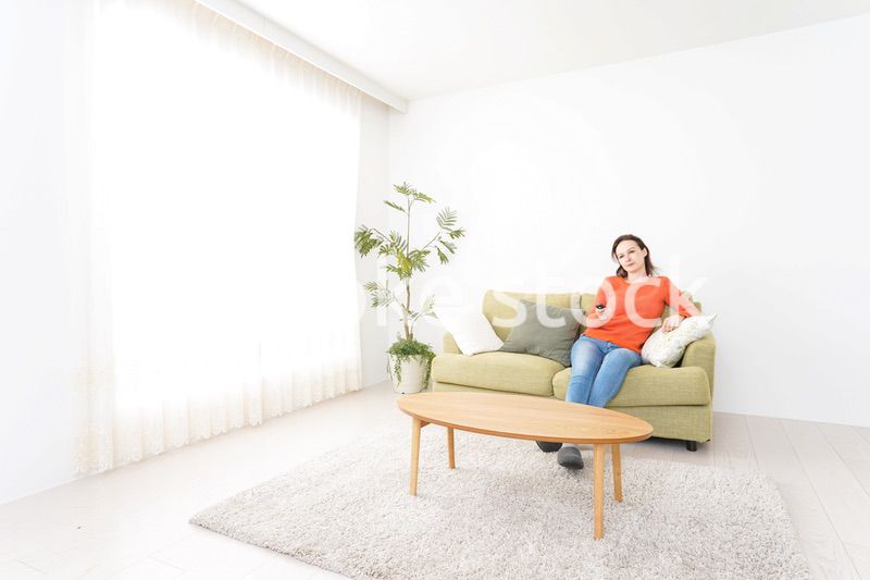 家でテレビを見る女性