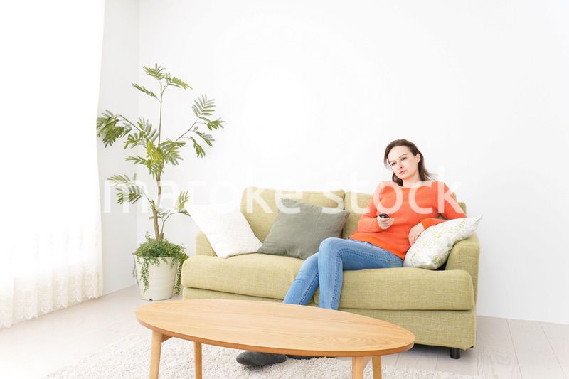 家でテレビを見る女性