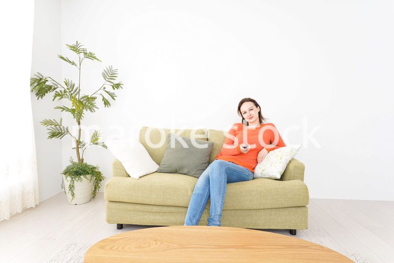 家でテレビを見る女性