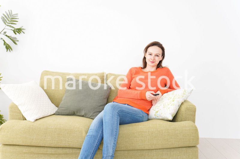 家でテレビを見る女性