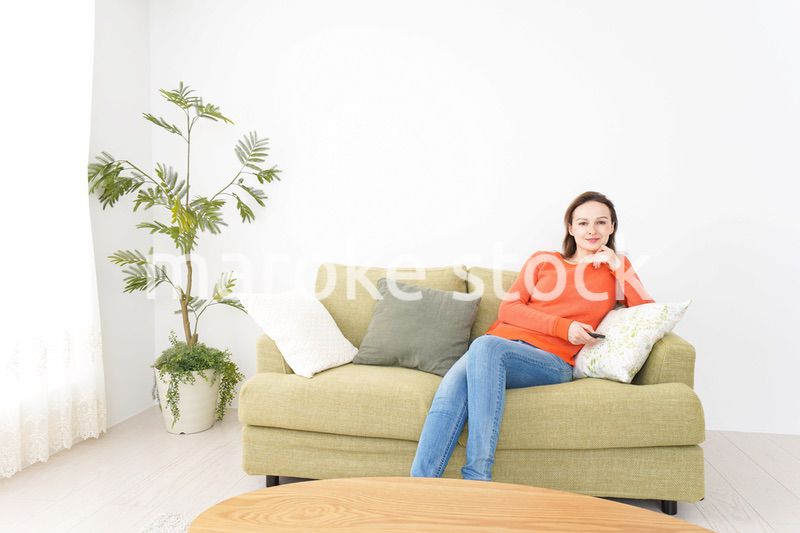 家でテレビを見る女性
