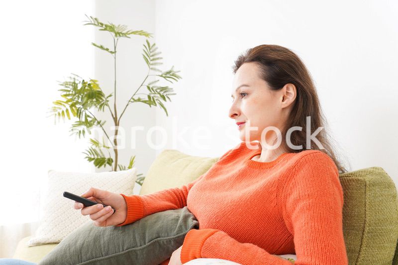 家でテレビを見る女性