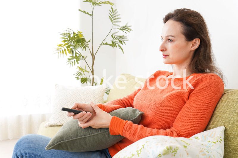 家でテレビを見る女性
