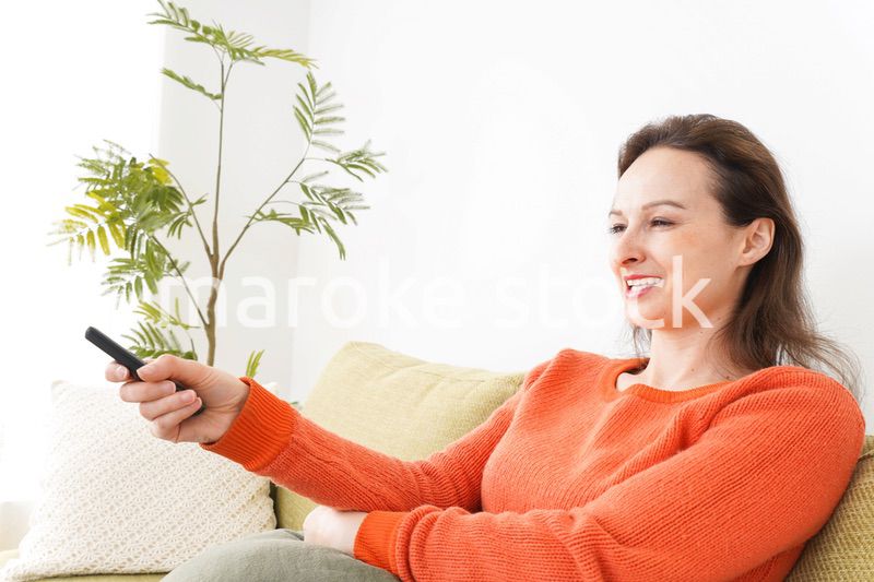 家でテレビを見る女性