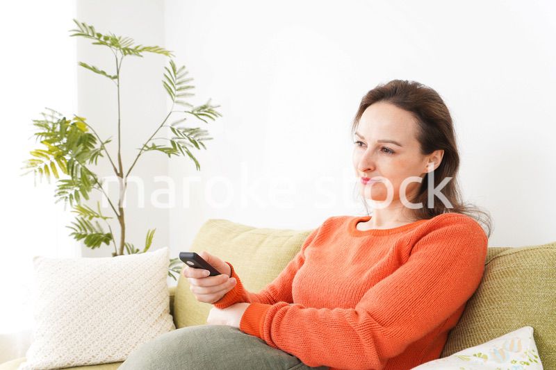 家でテレビを見る女性
