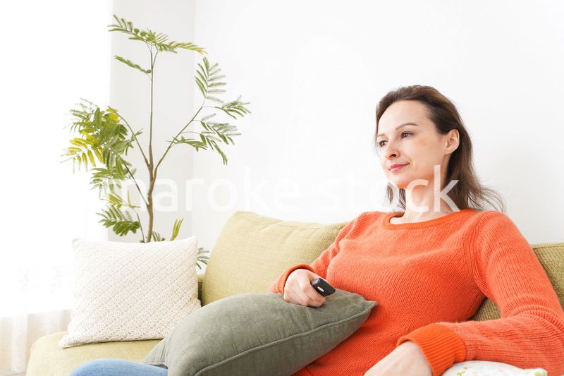 家でテレビを見る女性
