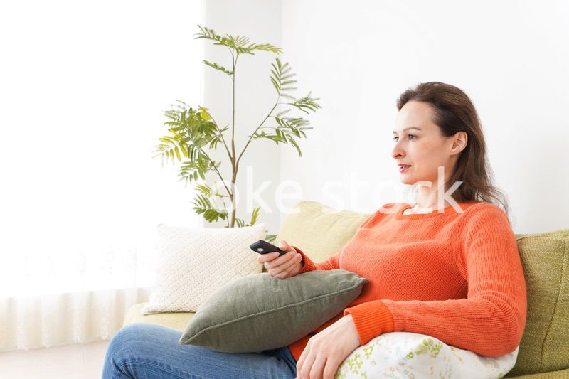 家でテレビを見る女性