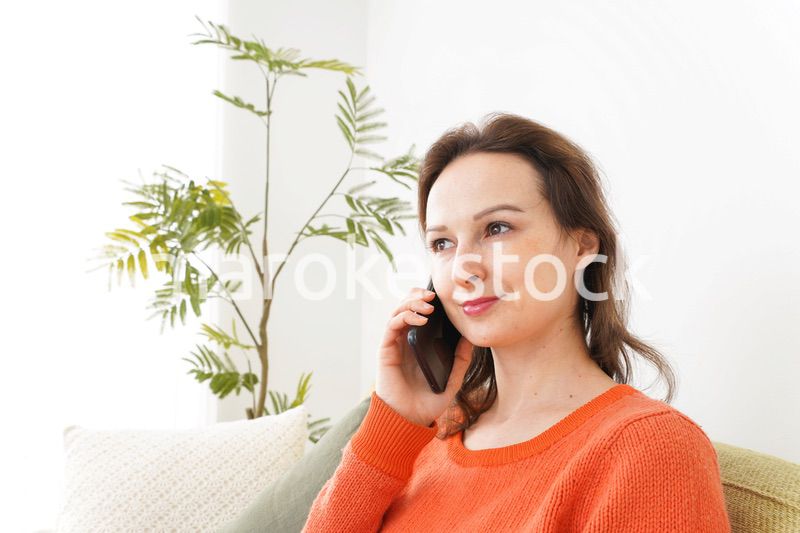 家で通話をする若い女性