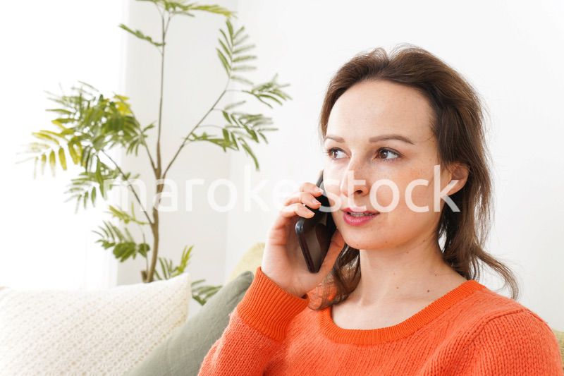 家で通話をする若い女性