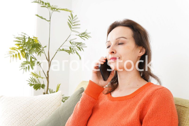 家で通話をする若い女性