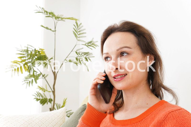 家で通話をする若い女性