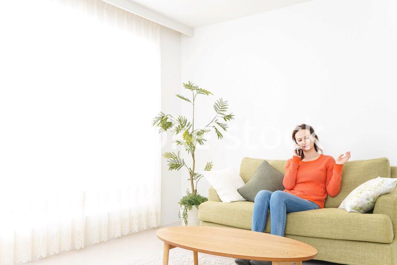 家で通話をする若い女性