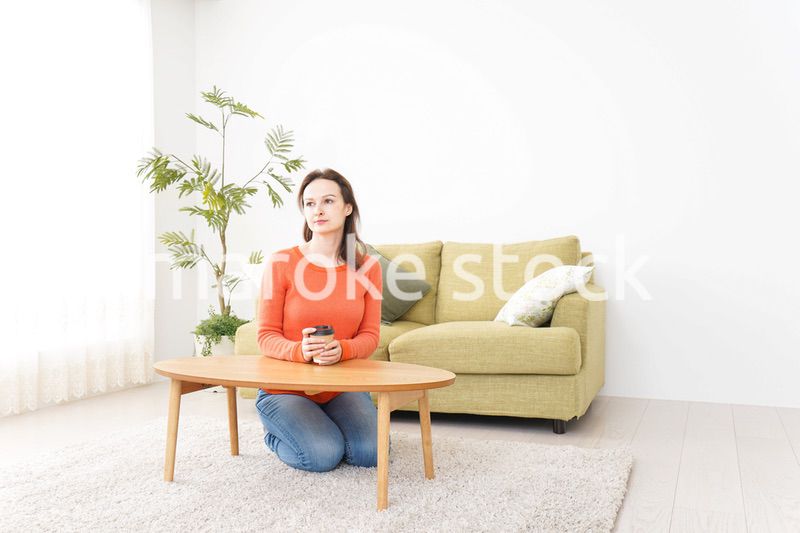 家でコーヒーを飲む若い女性