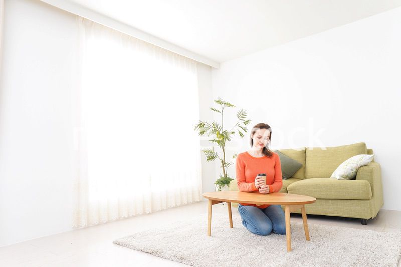 家でコーヒーを飲む若い女性