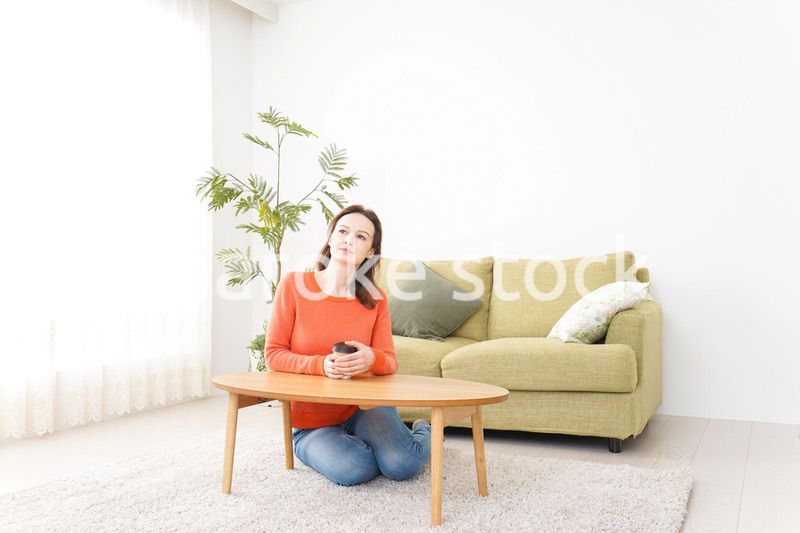 家でコーヒーを飲む若い女性